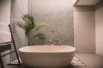 Salle de bain avec un mur en pierre et un style épuré (Jared Rice sur Unsplash)